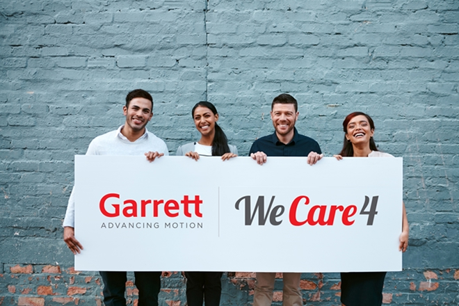 Four people holding a banner with Garret WeCare4